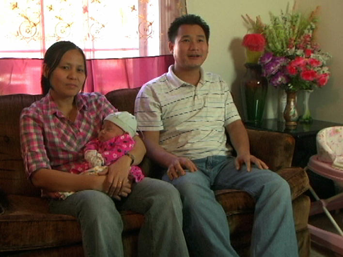 A couple with their baby at home