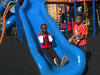 Darfuri girl going down a school playground slide