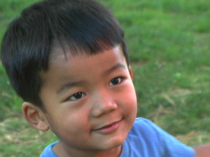 Young boy from Burma smiling at the camera